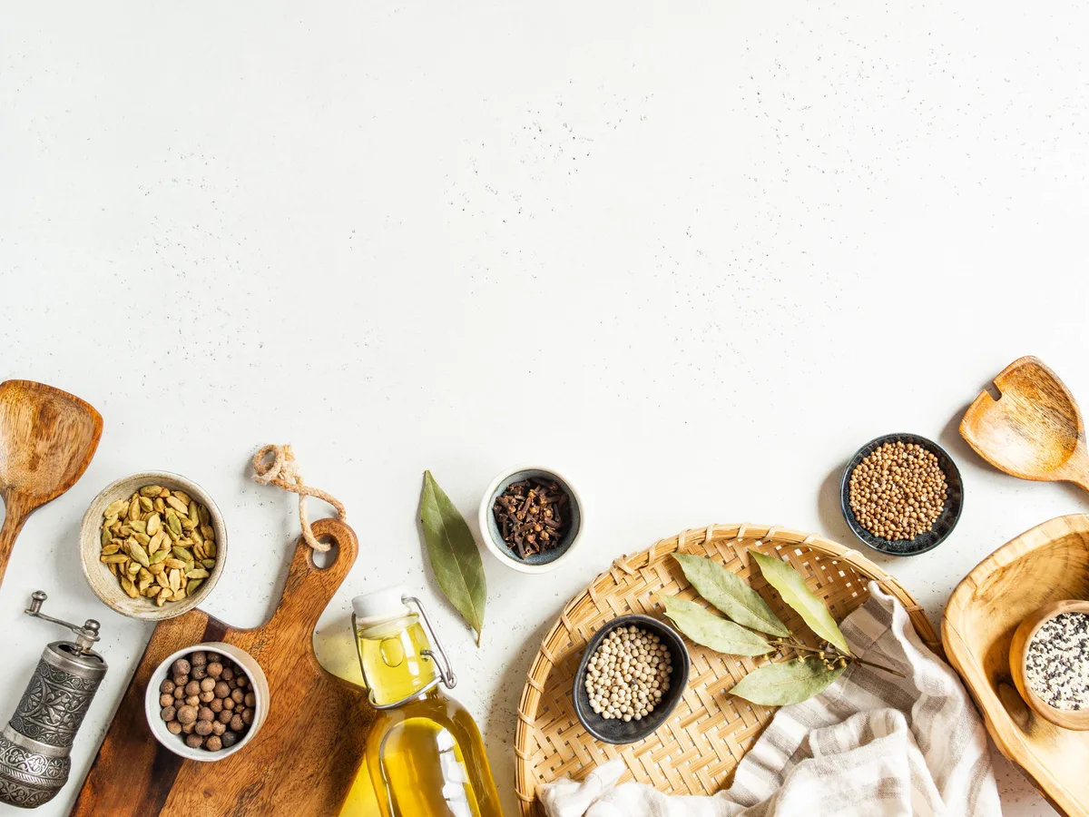Flat lay of spice bowls and olive oil on a light background